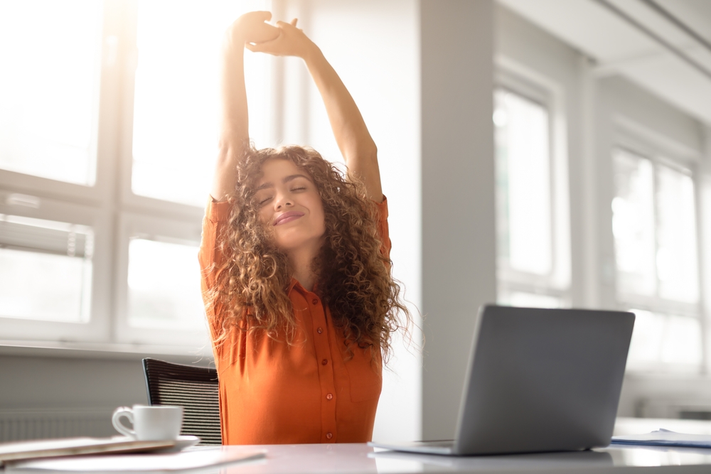 work-life balance self-care woman stretching at desk